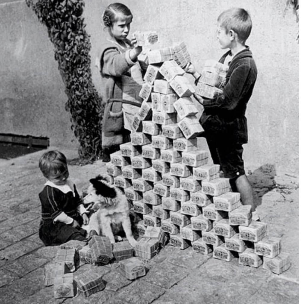 ​​​​​​​Дети строят дом из пачек с банкнотами